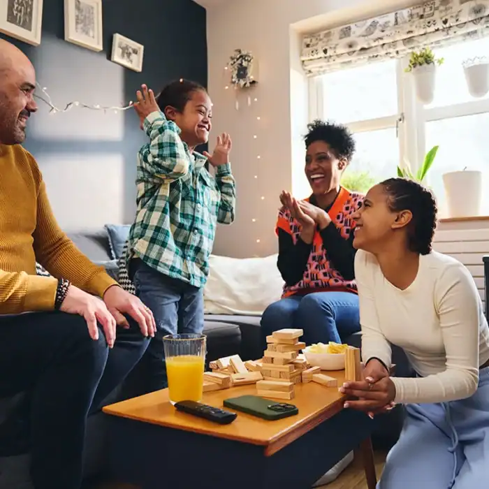 Mother, father and two children laughing together while playing a game
