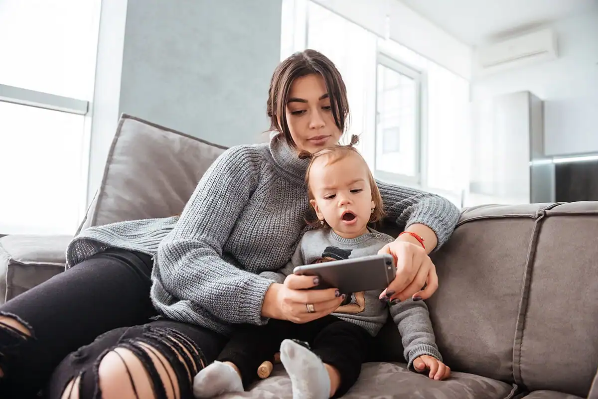 Mother and young daughter looking at a smartphone together