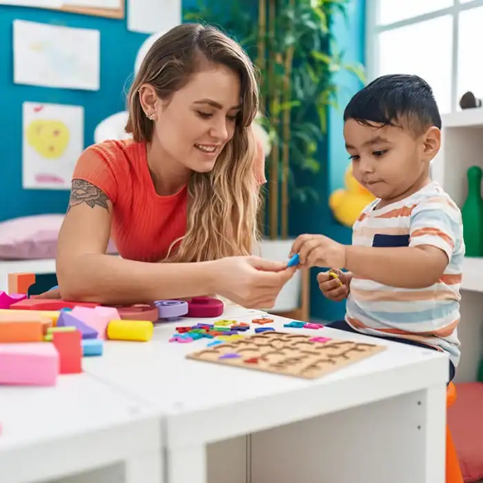 Preschool teacher handing toy letters to a young child