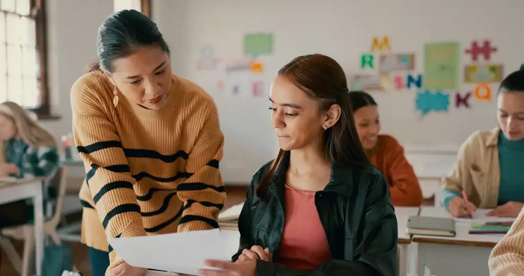 Educator working alongside a student in a classroom